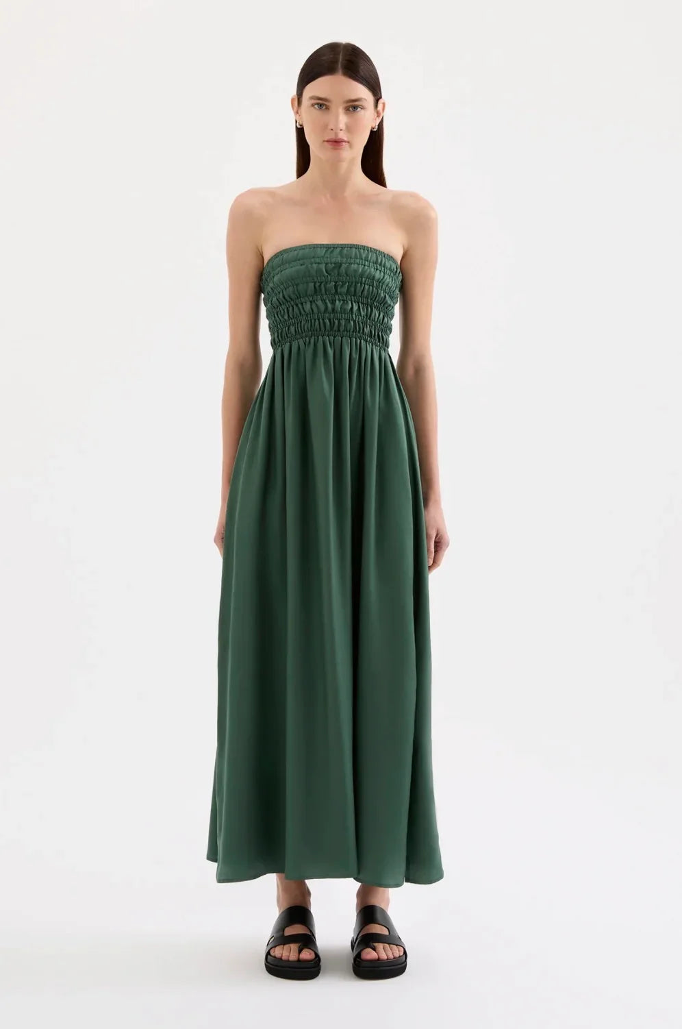 Woman in strapless green maxi dress with ruched bodice and black sandals