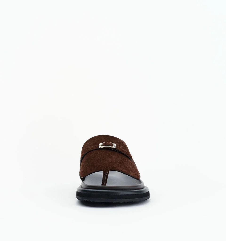 Brown suede slide sandals with a silver buckle detail on a black sole