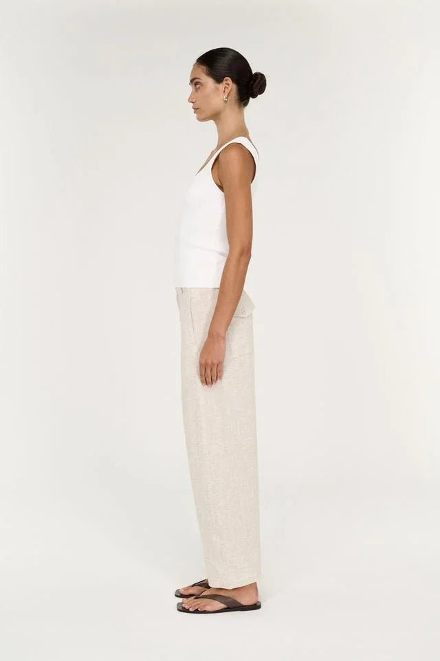 Woman in a white tank top wearing STAPLE THE LABEL Neve Linen Barrel Leg Pants in oatmeal.