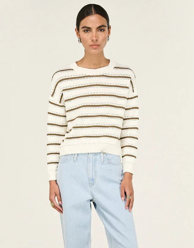 Cream and brown striped knit sweater with relaxed fit, paired with light wash jeans
