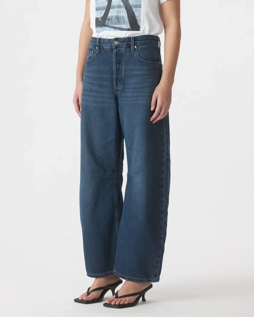 Wide leg blue denim jeans with high waist, paired with black heeled sandals for women's fashion