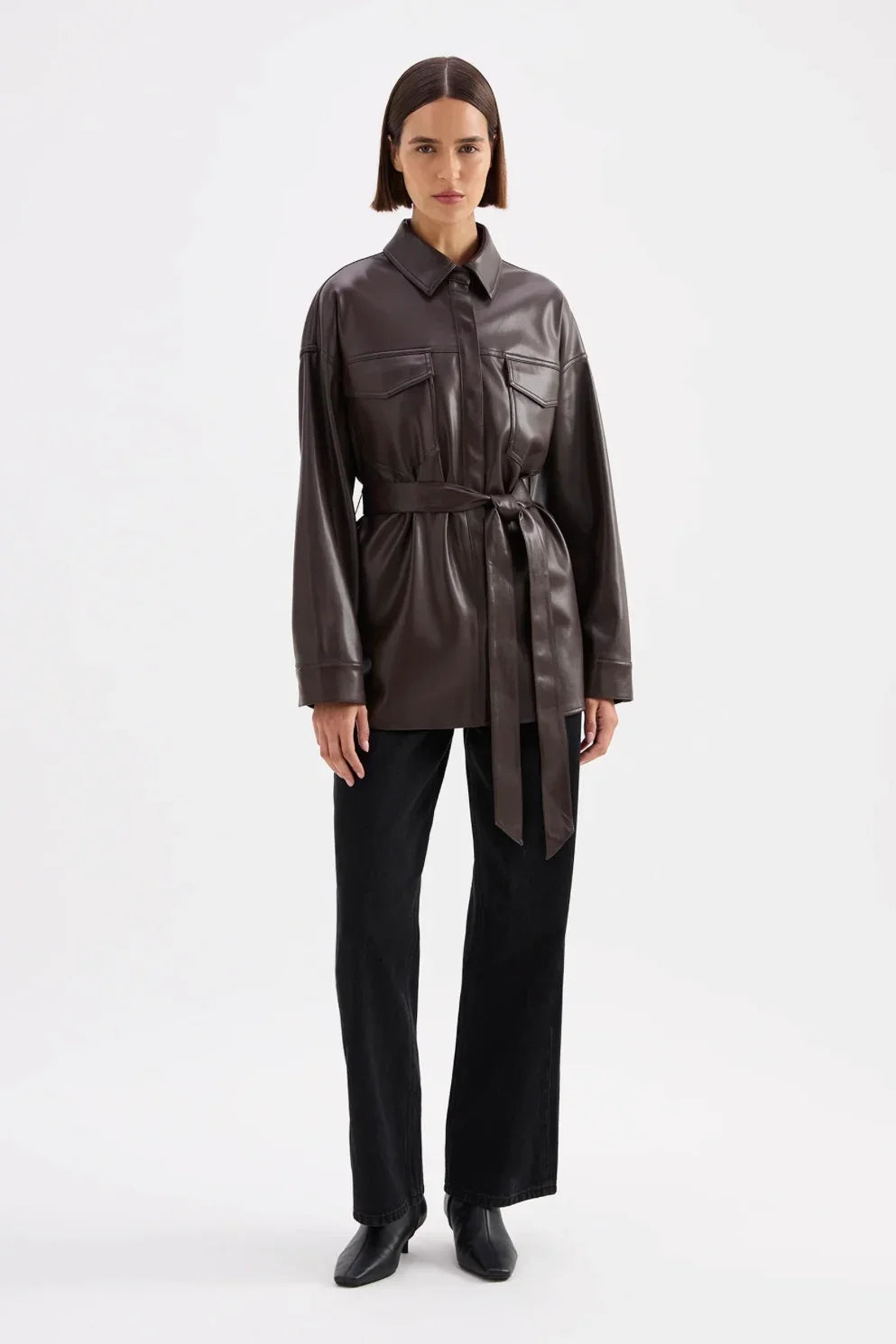 Brown leather shirt jacket with belt, paired with black pants and boots