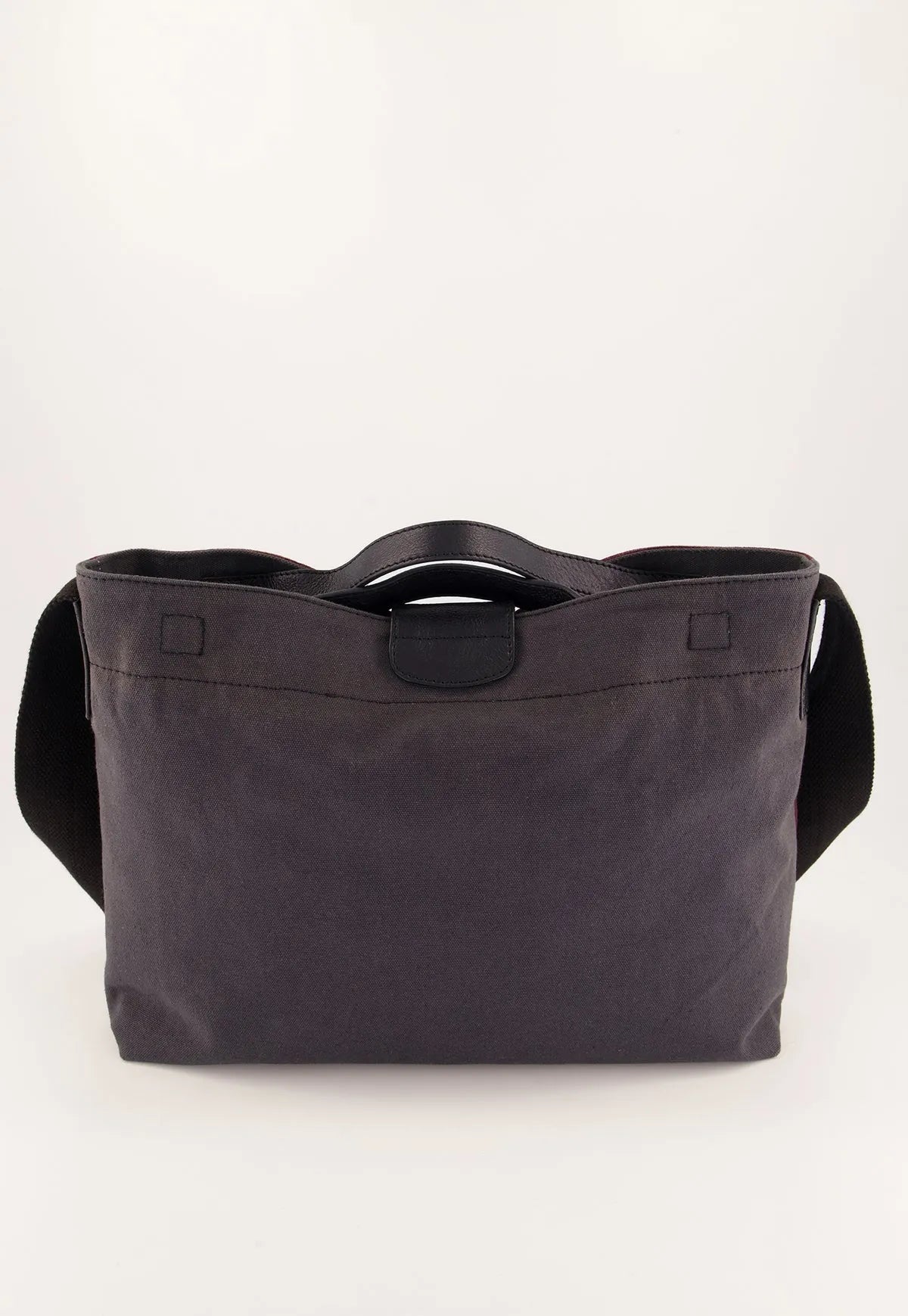 Dark grey canvas tote bag with black leather handles and shoulder strap, minimalist women's fashion accessory