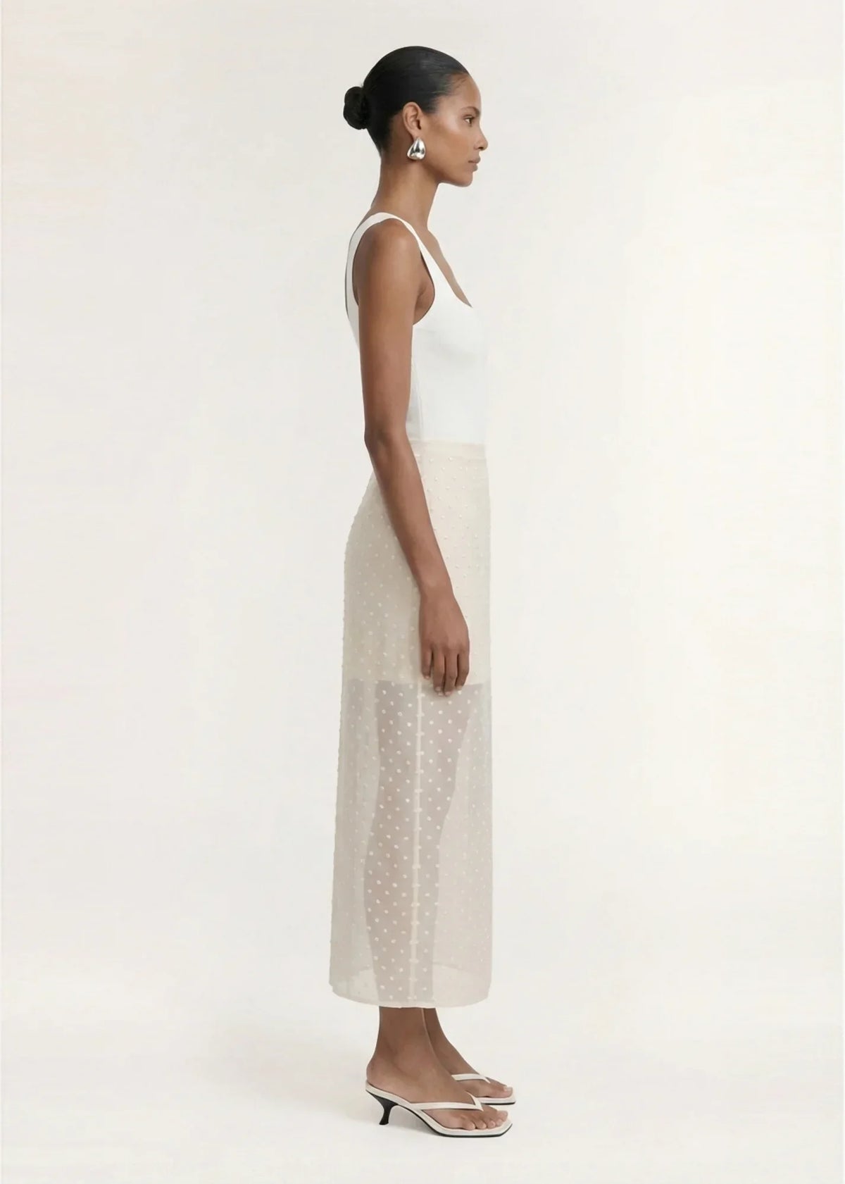 Woman in a white top and STAPLE THE LABEL Etoile Layered Midi Skirt in Cream Spot