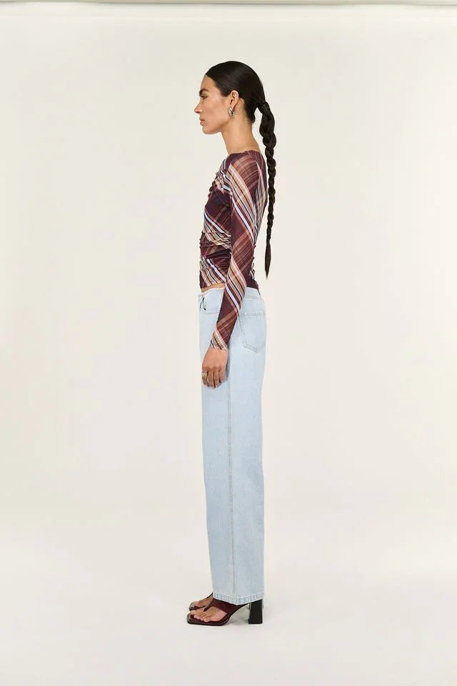 Woman in plaid top and light blue jeans, stylish fashion outfit