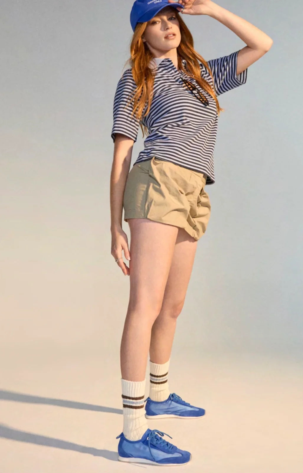 Woman wearing Rollie Cruz Sneakers in Cobalt Mesh with khaki shorts and a striped shirt.