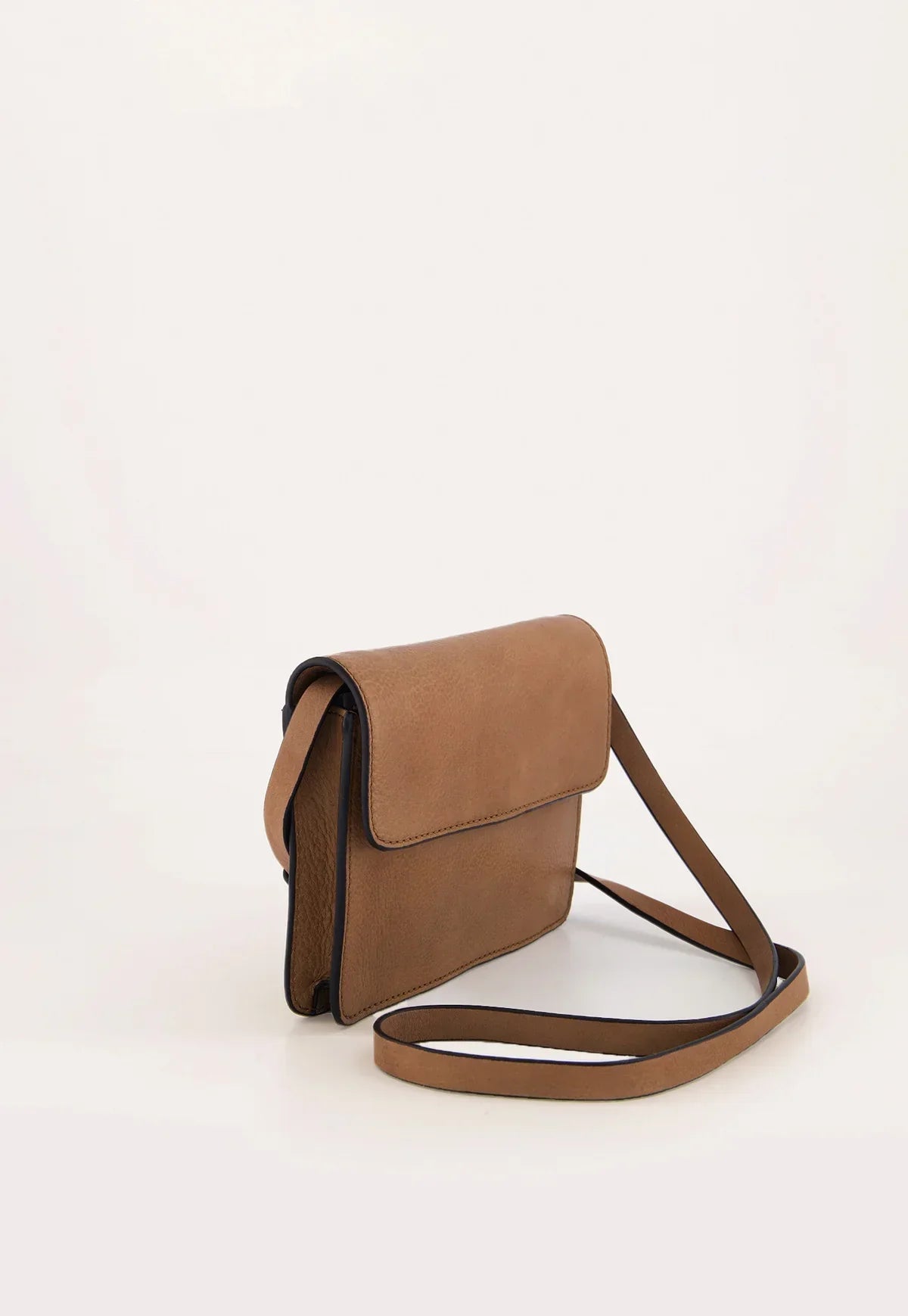 Tan leather crossbody bag with flap closure and long strap on white background
