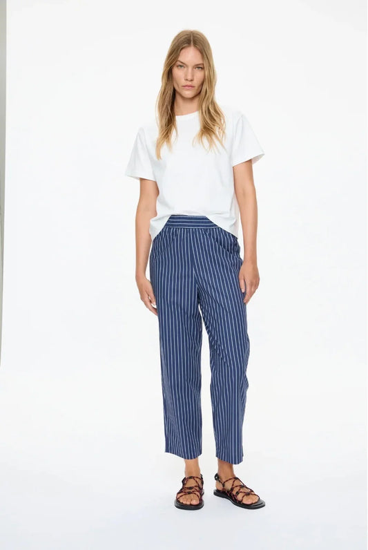 Woman wearing LMND Mimi Cropped Straight Leg Pants in blue stripe and a white t-shirt.