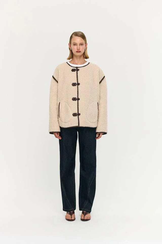 Cream teddy coat with toggle buttons, paired with dark wide-leg jeans and sandals, women's fashion