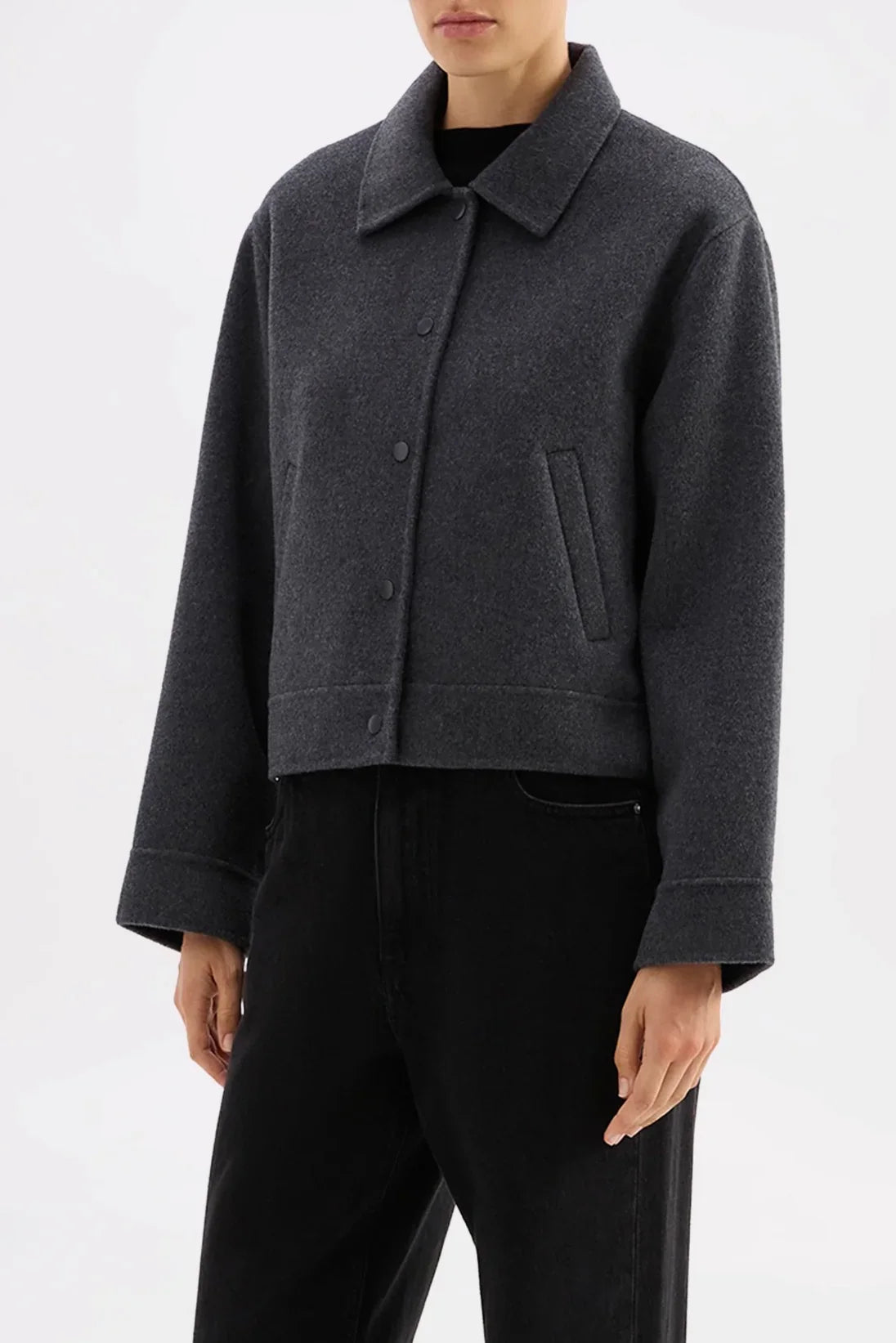 Dark gray cropped wool coat with button front and collar, paired with black pants