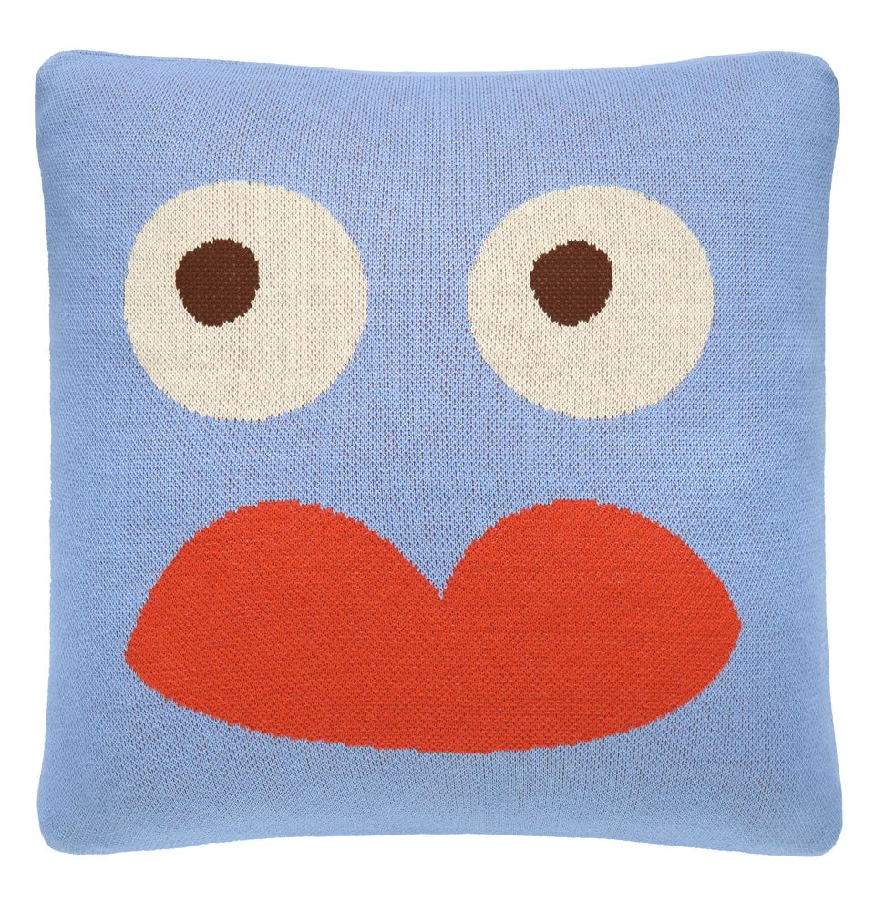 Light blue knit face cushion with large white eyes and bright red lips.