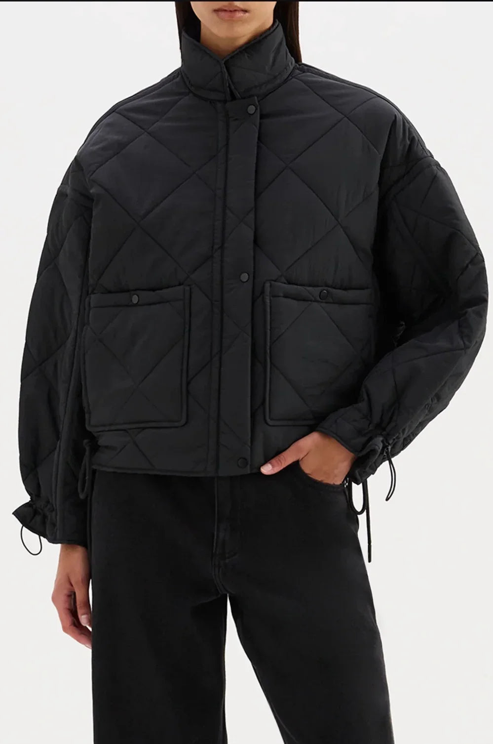 Black quilted puffer jacket with diamond stitching, front pockets, and drawstring cuffs for women's fashion