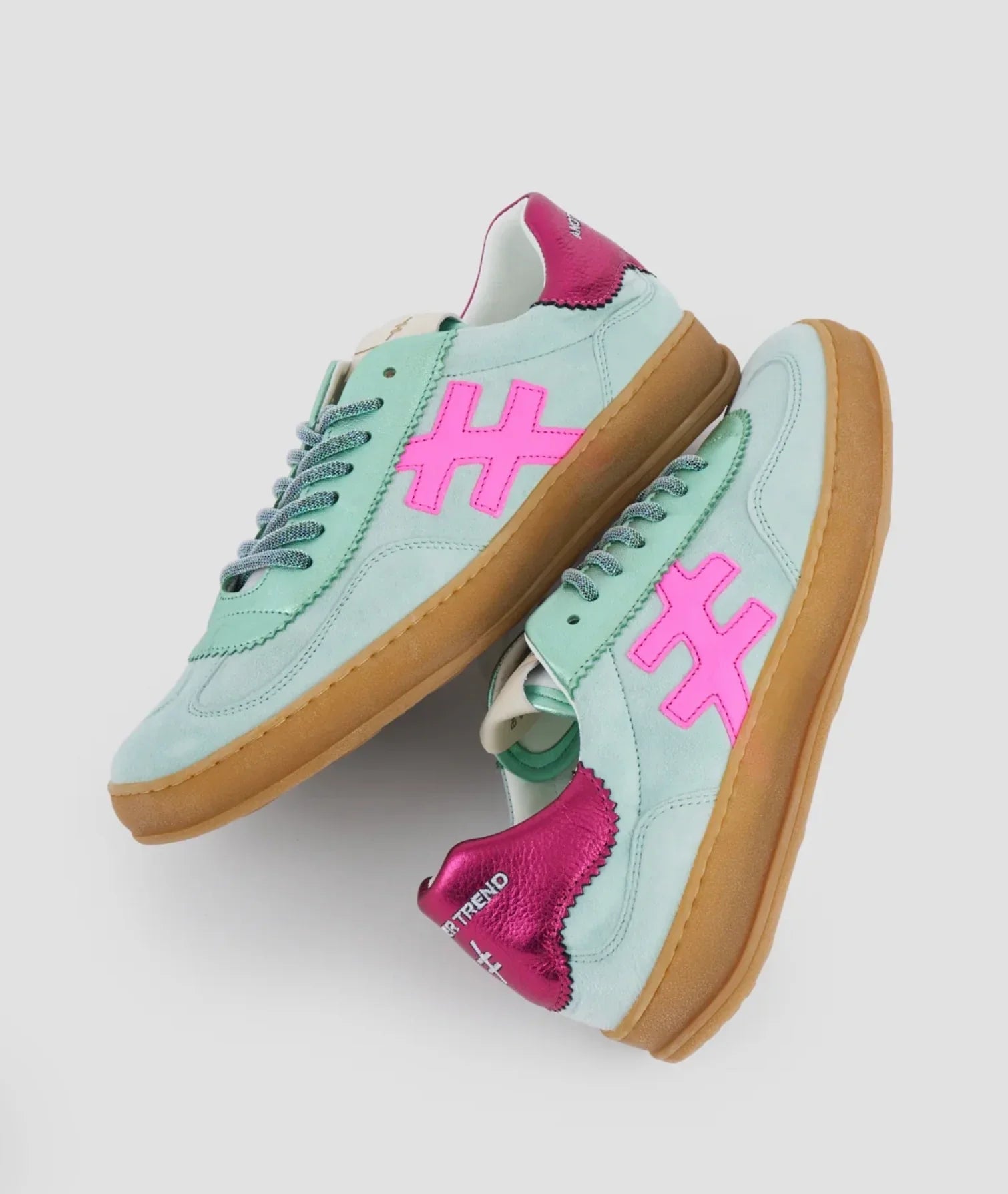 Pair of light blue suede sneakers with pink logo accents and gum soles.