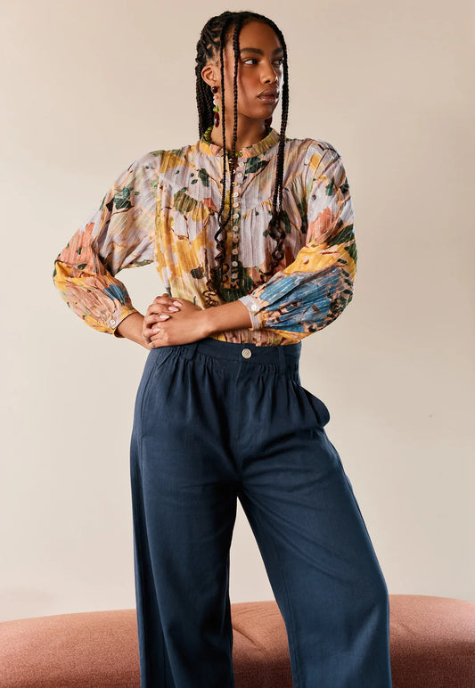 Woman wearing NANCYBIRD Charlotte Pant in Steel Blue and a colorful printed blouse.