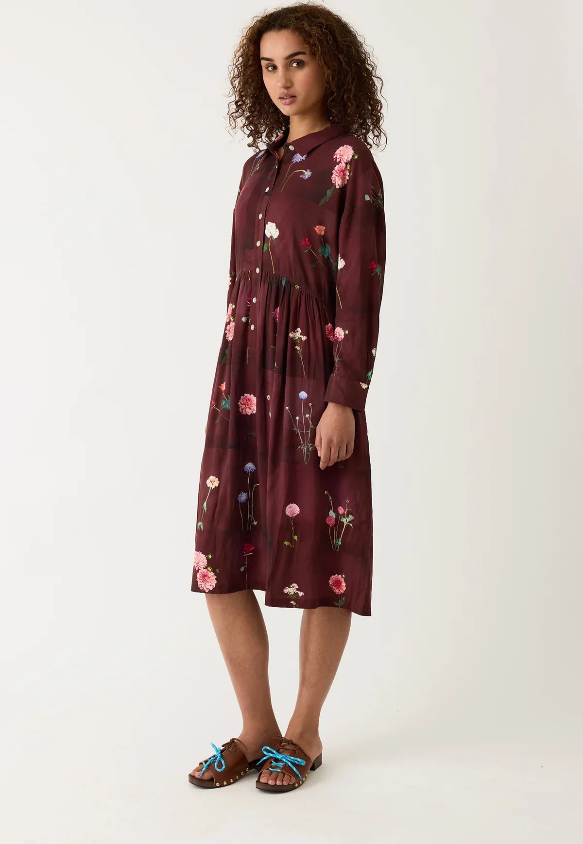 Burgundy floral print shirt dress with long sleeves, button front, and midi length, paired with brown sandals.
