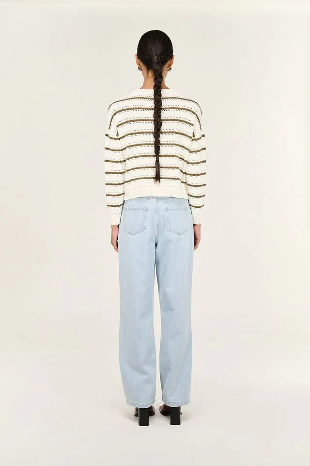 Woman wearing striped knit sweater and light blue wide-leg jeans, back view