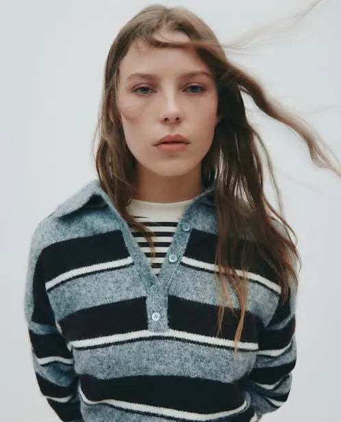 Woman in striped knit polo sweater, layered over striped tee, for chic everyday style