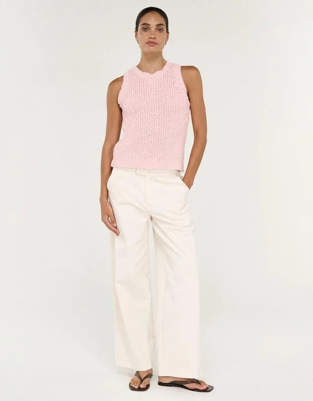 Woman wearing STAPLE THE LABEL Cove Knit Tank in Rose Pink and white wide-leg pants.