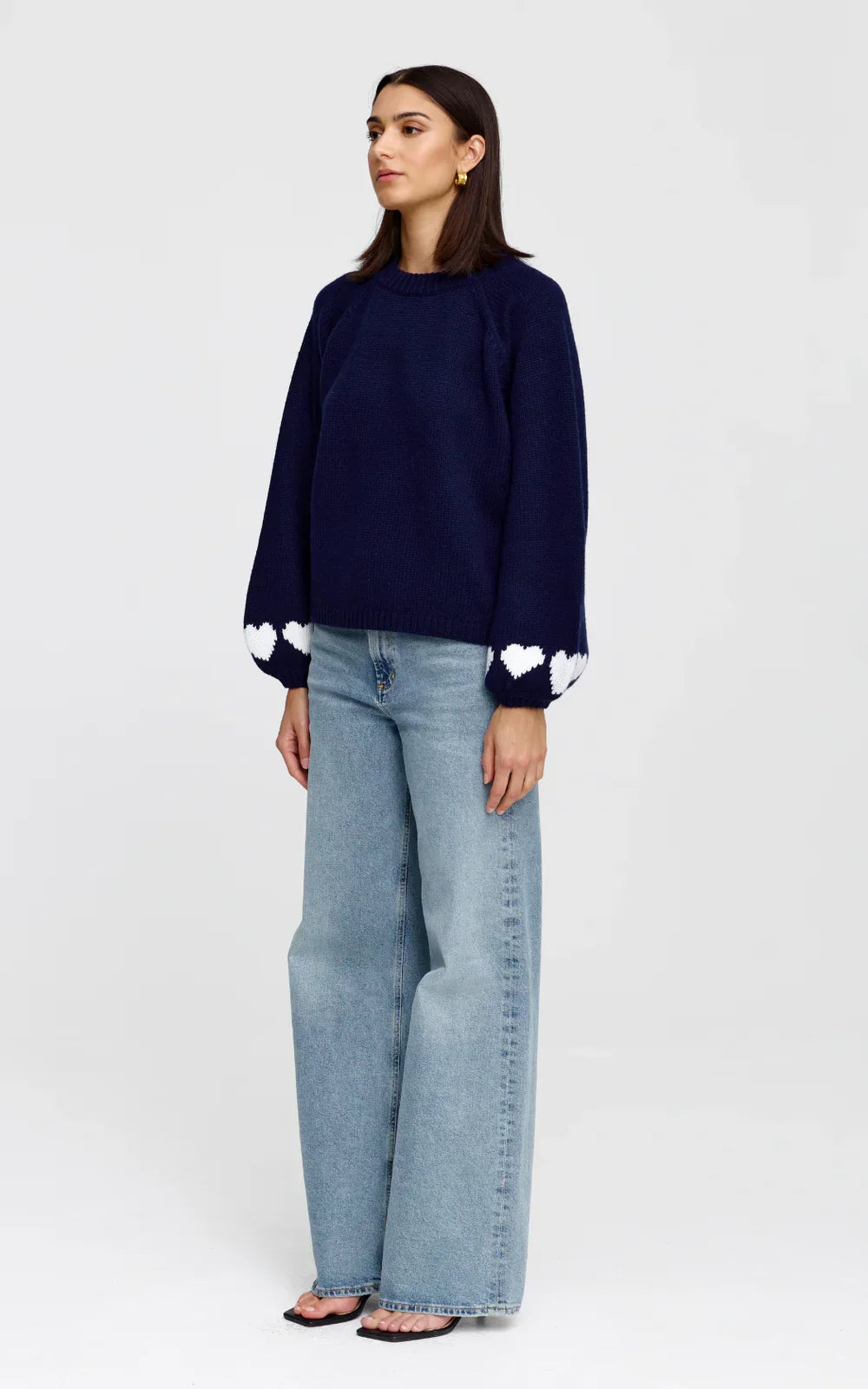 Navy knit sweater with white heart details on sleeves, paired with wide-leg jeans for women's fashion
