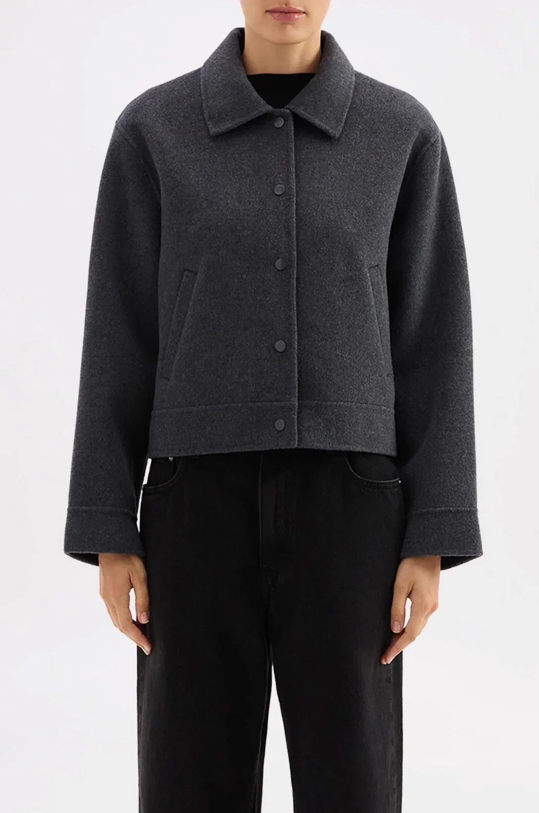 Dark gray cropped wool coat with button front and collar, paired with black jeans