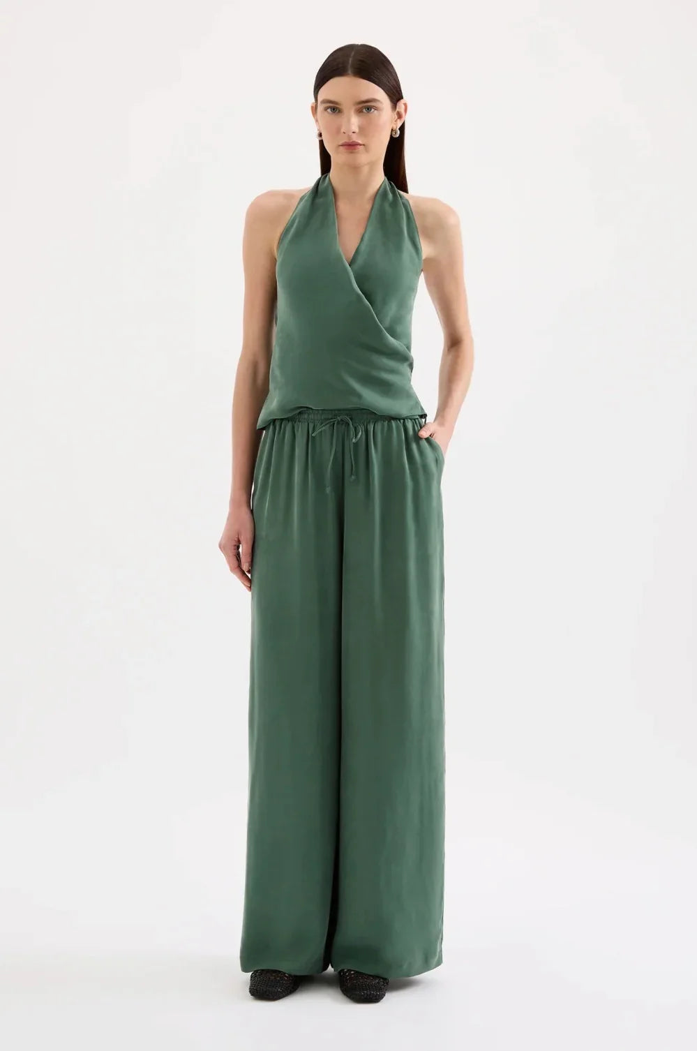 Woman in sage green halter neck top and wide leg pants set, neutral background