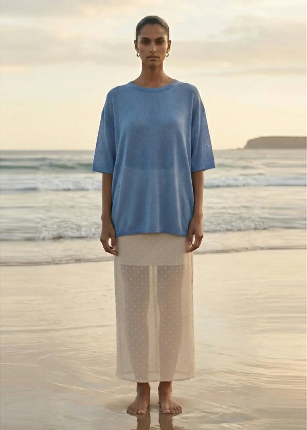 Woman wearing STAPLE THE LABEL Orla Oversized Knit Tee in Dusty Blue on a beach