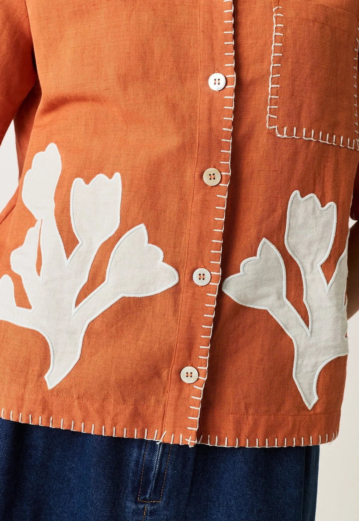Close-up of NANCYBIRD Summer Shirt in Blossom Appliqué in burnt orange linen.