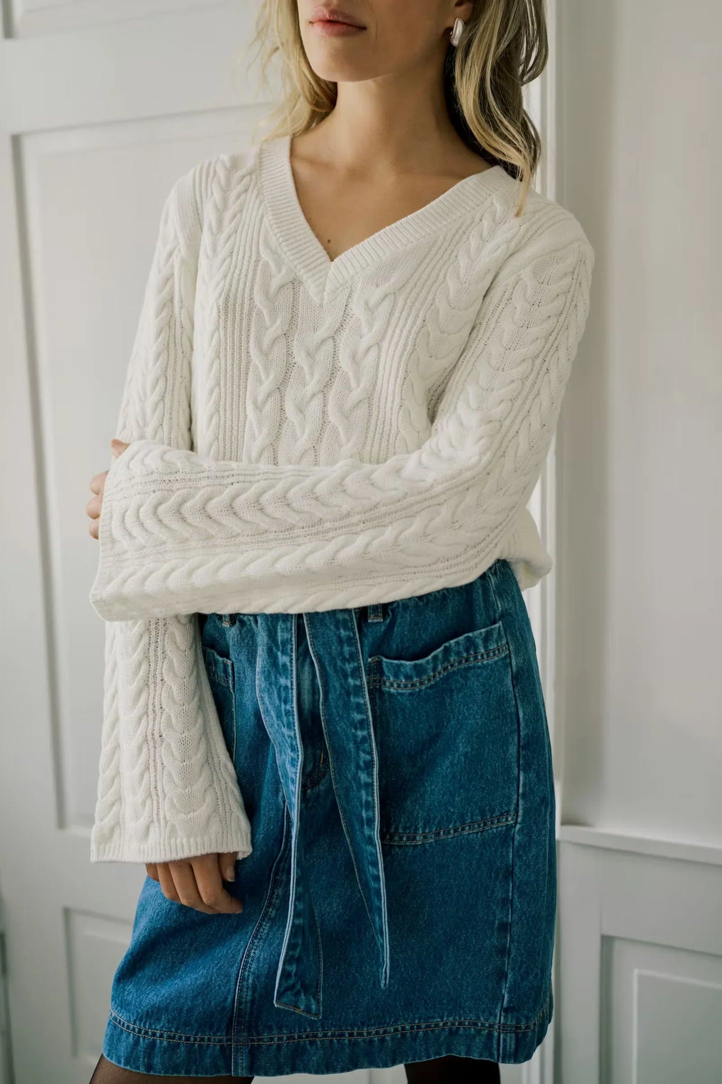 White cable knit V-neck sweater with bell sleeves paired with blue denim skirt, women's fashion