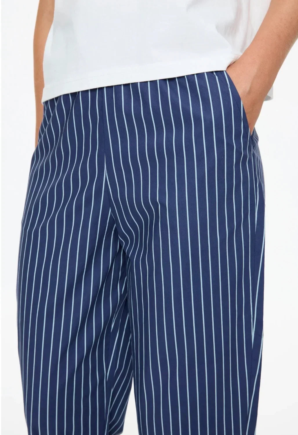 Close-up of LMND Mimi cropped straight leg pants in navy blue with white pinstripes.