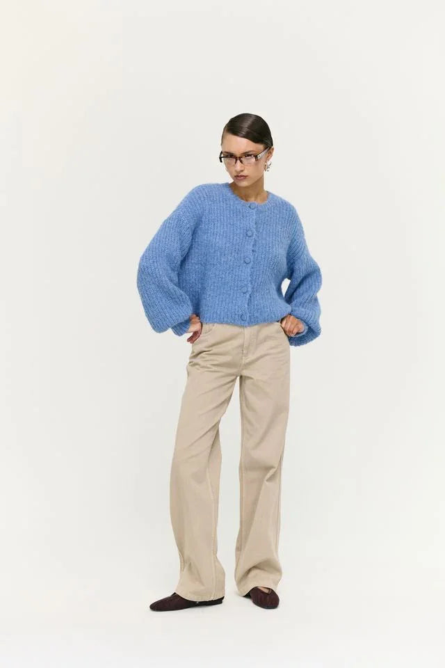 Woman in blue fuzzy cardigan, beige wide-leg pants, and brown flats, stylish women's fashion outfit