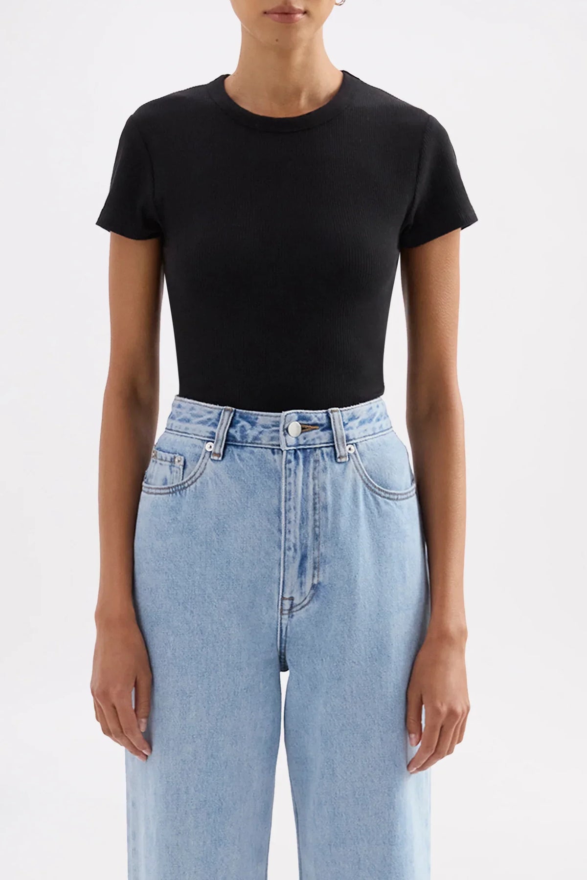 Model wearing a Nude Lucy Organic Rib SS Tee in black paired with light blue jeans