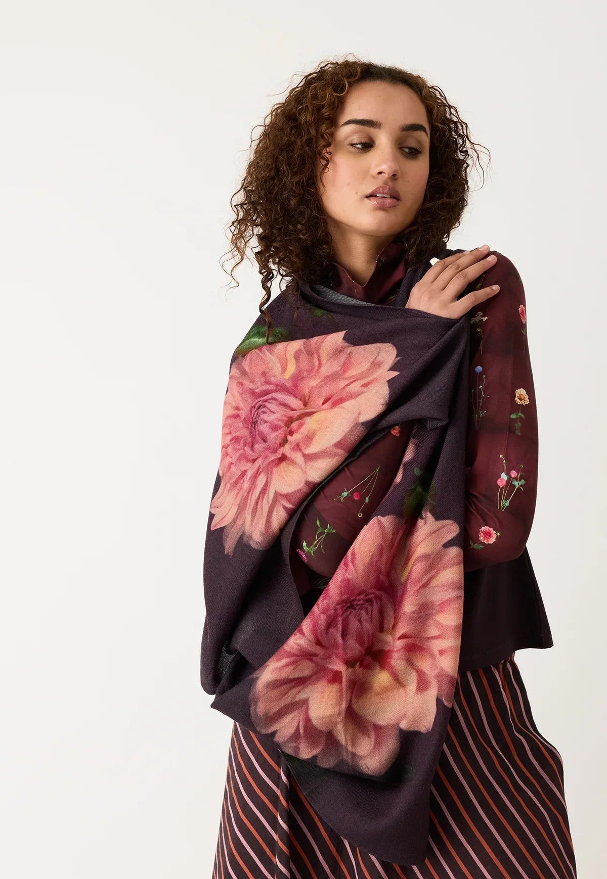 Woman wearing floral print scarf with large pink flowers and burgundy floral blouse
