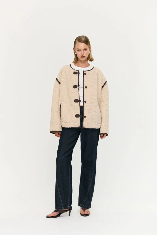 Cream shearling jacket with toggle buttons, styled with dark denim jeans and heeled sandals for women's fashion