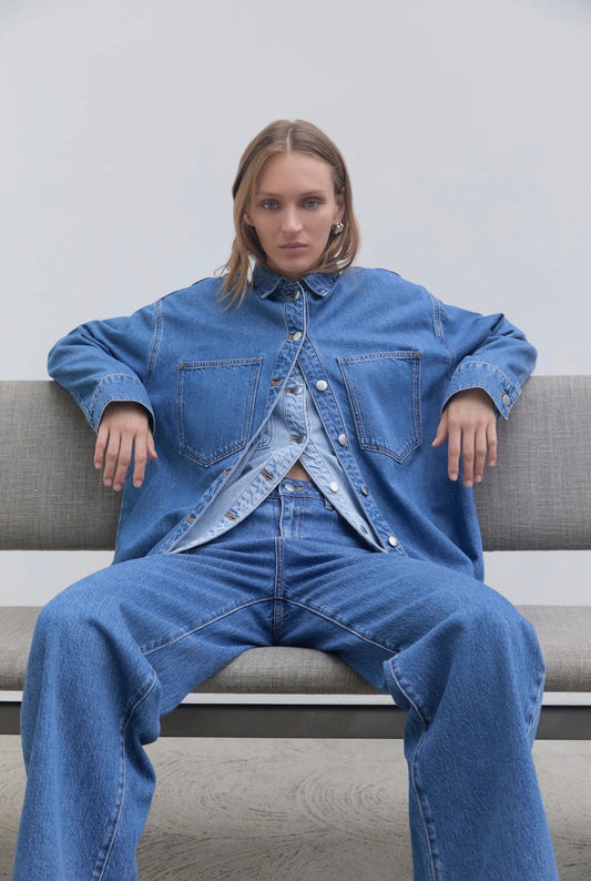 Woman in oversized denim shirt and wide-leg jeans, stylish casual outfit