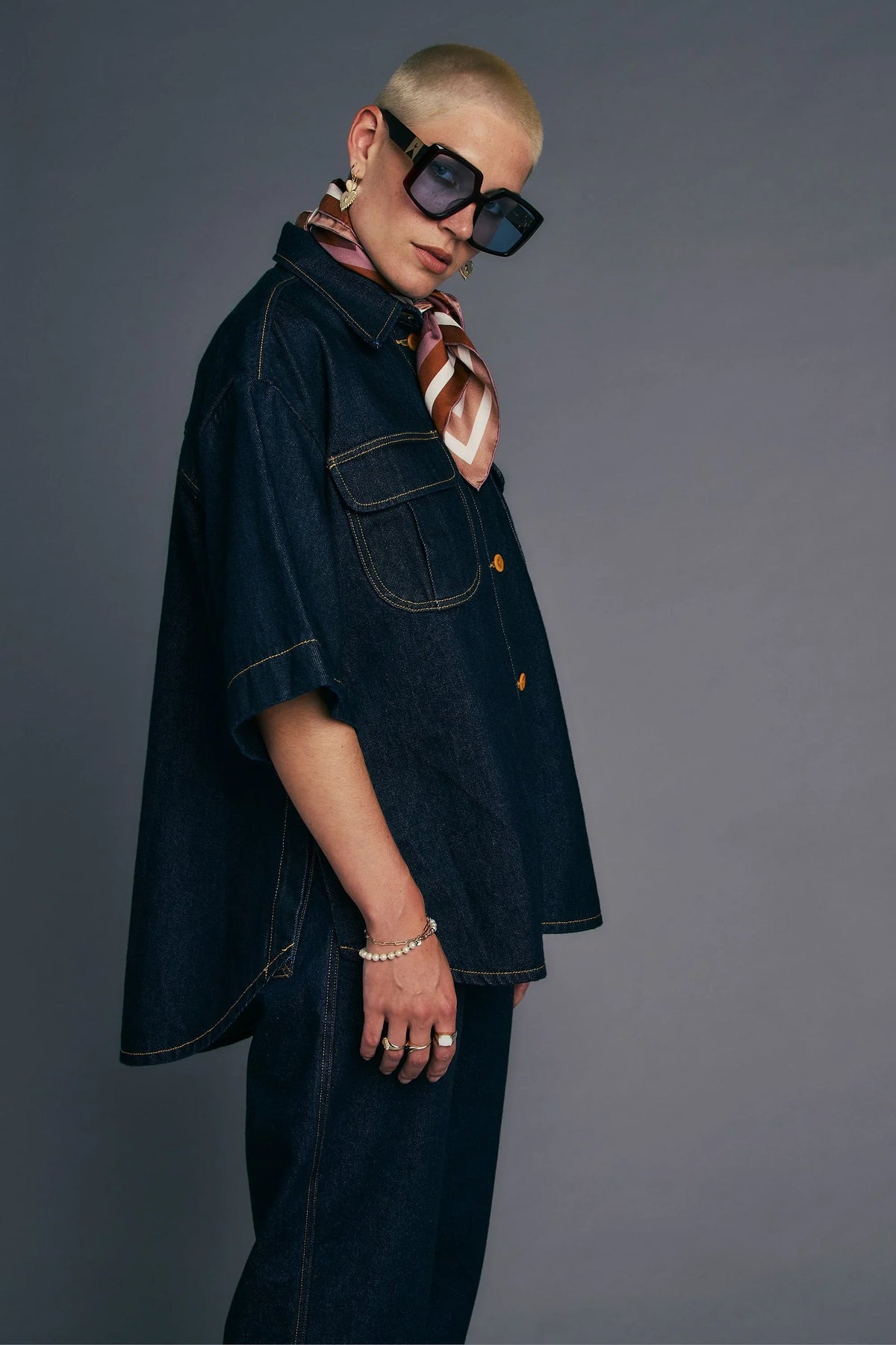 Model wearing an Outland Denim X Karen Walker Mod Shirt in indigo with accessories.