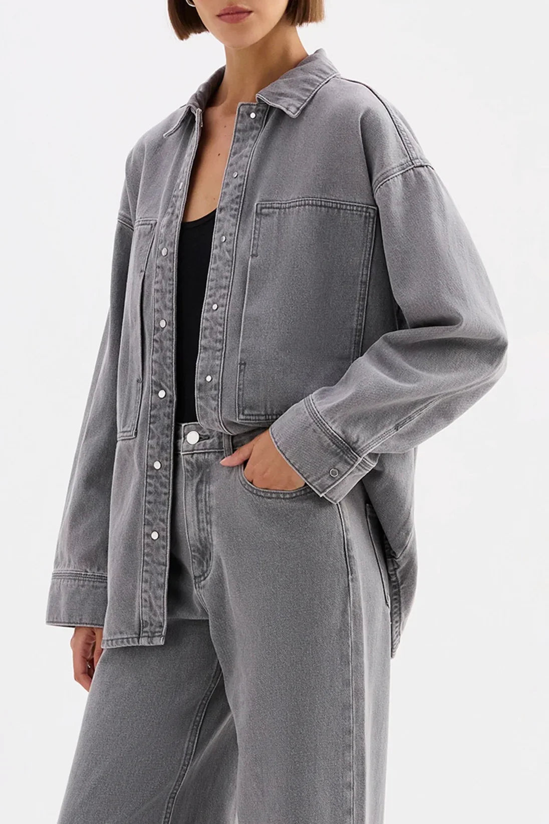 Woman wearing oversized grey denim shirt jacket and wide-leg jeans, casual fashion