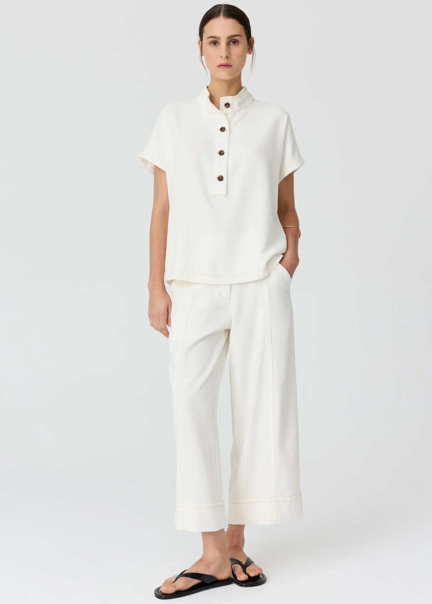Woman wearing the POL Anise Shirt, a white short-sleeve button-up top and matching wide-leg trousers.