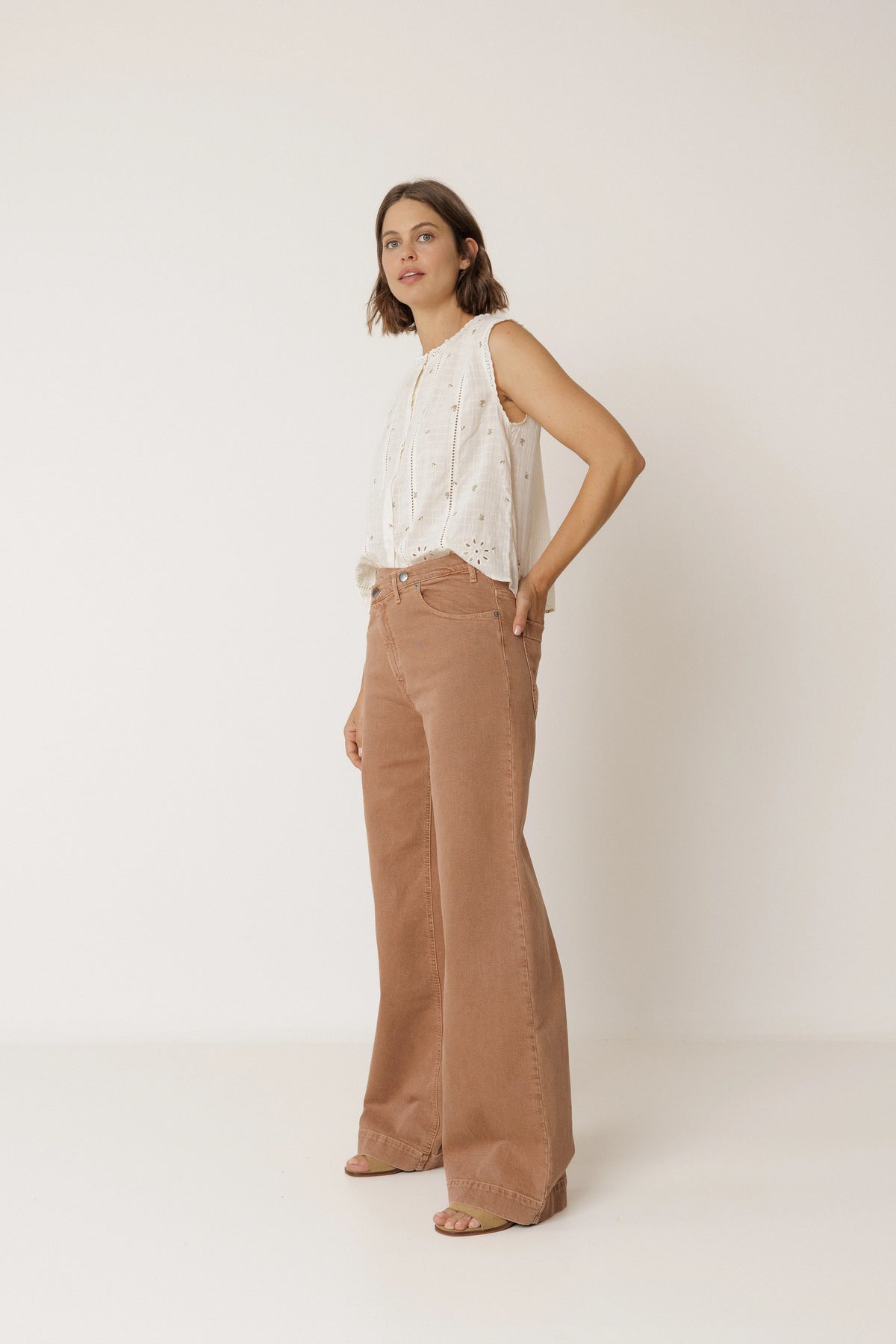 Woman wearing an INDI & COLD Stamp Print Sleeveless Shirt and brown wide-leg trousers.