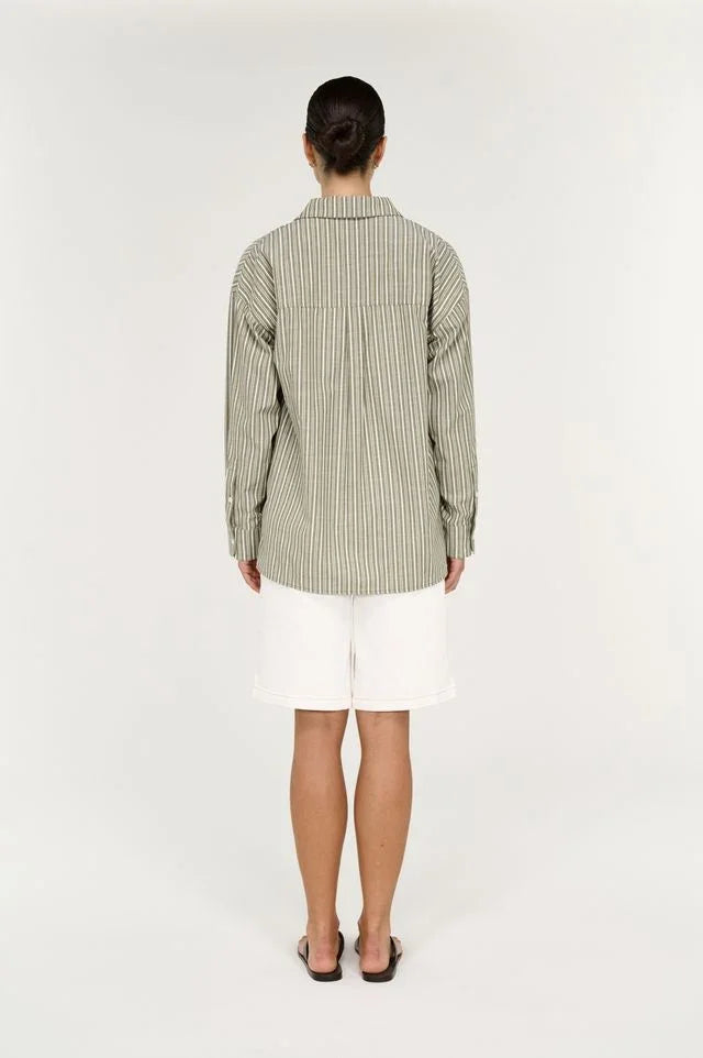 Back view of a person wearing a STAPLE THE LABEL Lisara Oversized Shirt in khaki and white stripe.