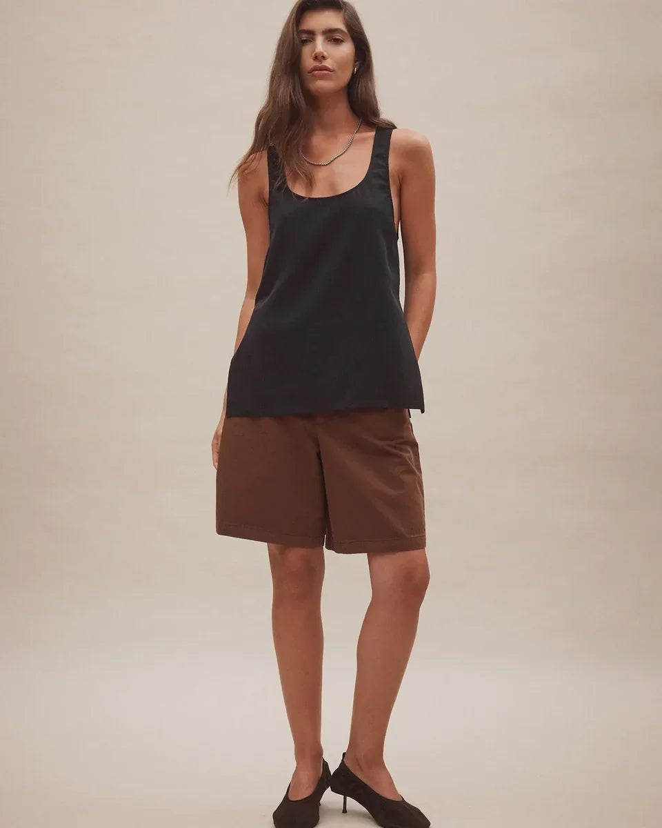 Woman wearing Nobody Denim Rowan Bermuda Shorts in coffee with a black tank top