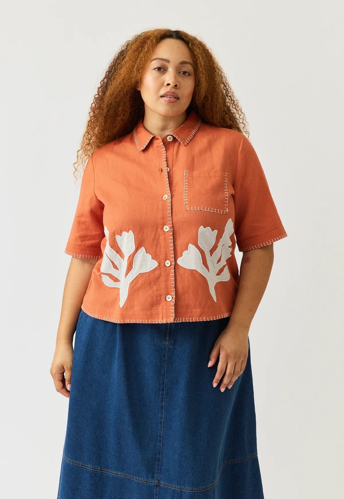 Woman wearing NANCYBIRD Summer Shirt in Blossom Appliqué with a blue denim skirt