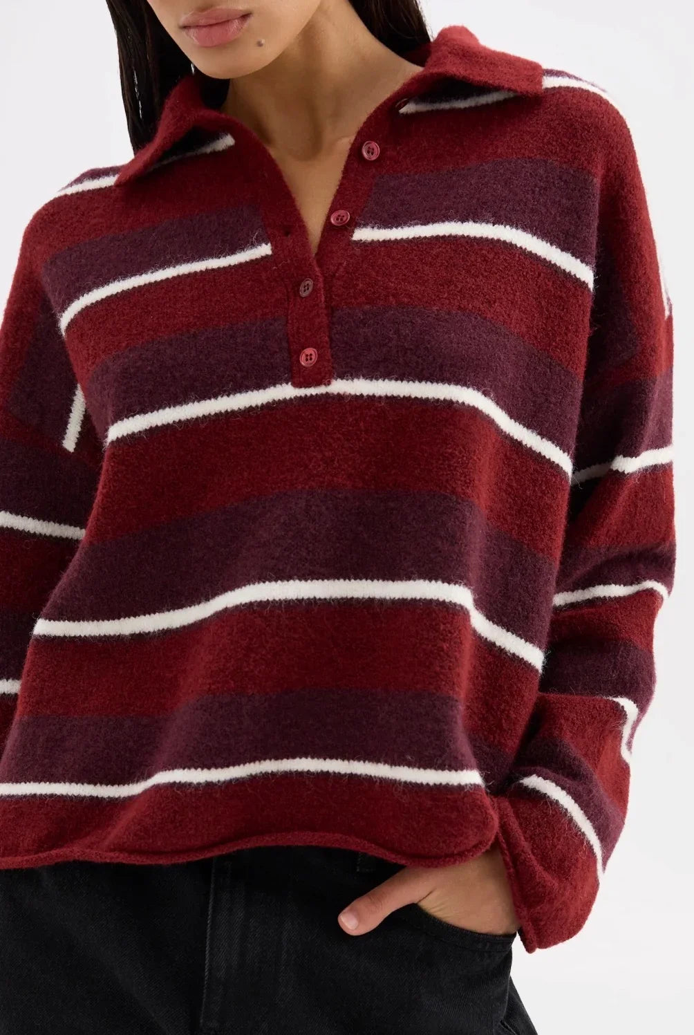 Woman wearing a burgundy and white striped knit polo sweater with buttons