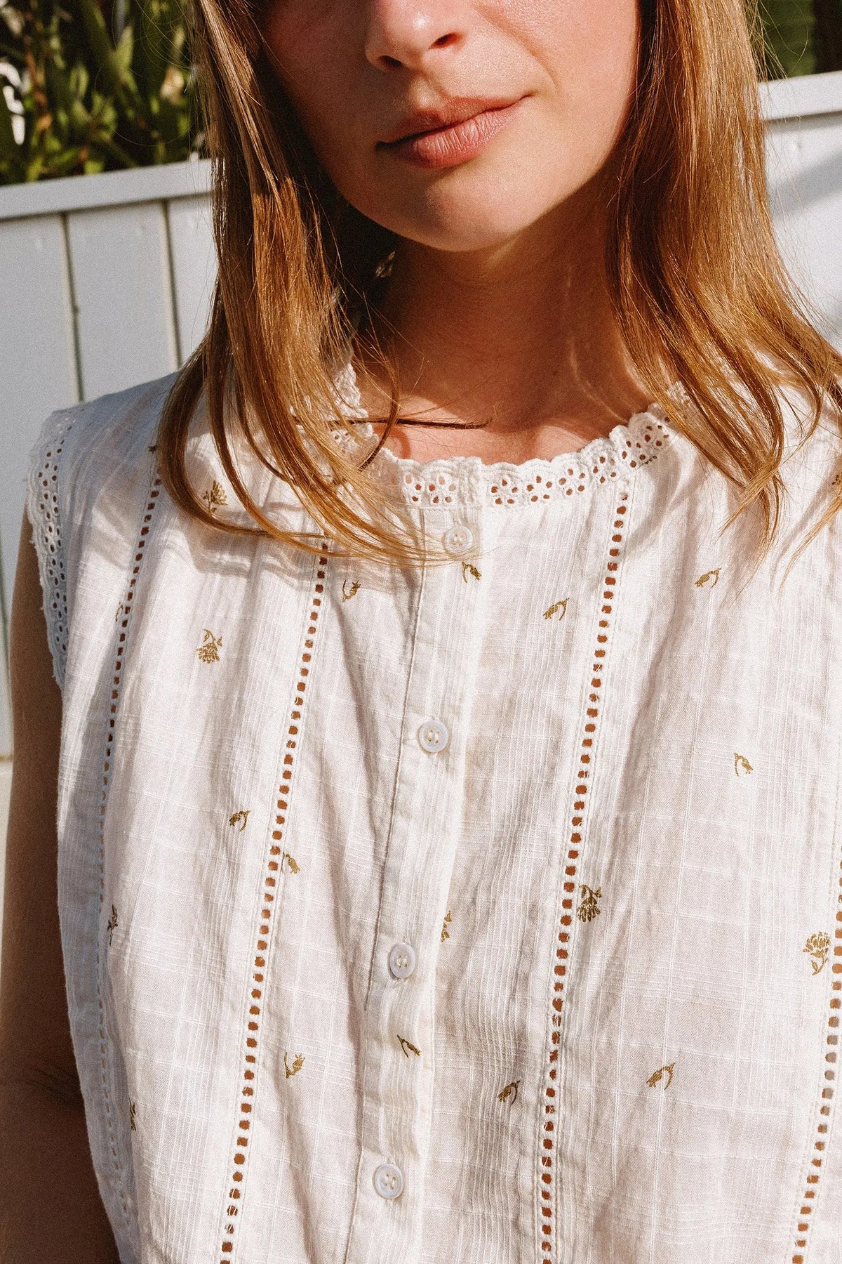 Close-up of the INDI & COLD Stamp Print Sleeveless Shirt in white with delicate embroidery.