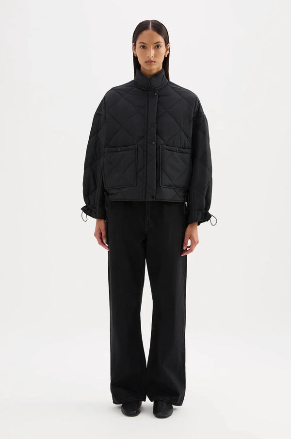 Black quilted jacket with front pockets and drawstring cuffs paired with wide-leg pants