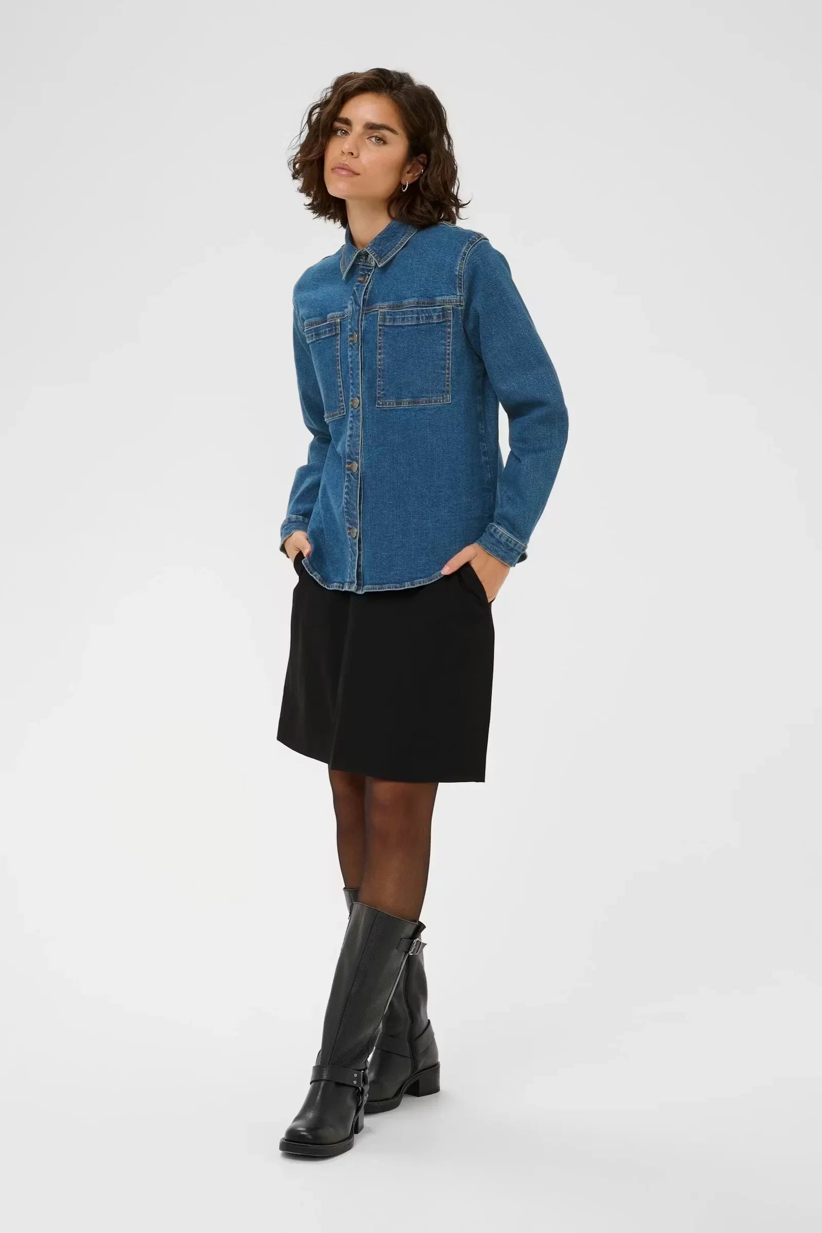 Woman in blue denim shirt, black skirt, and knee-high boots, stylish women's fashion outfit