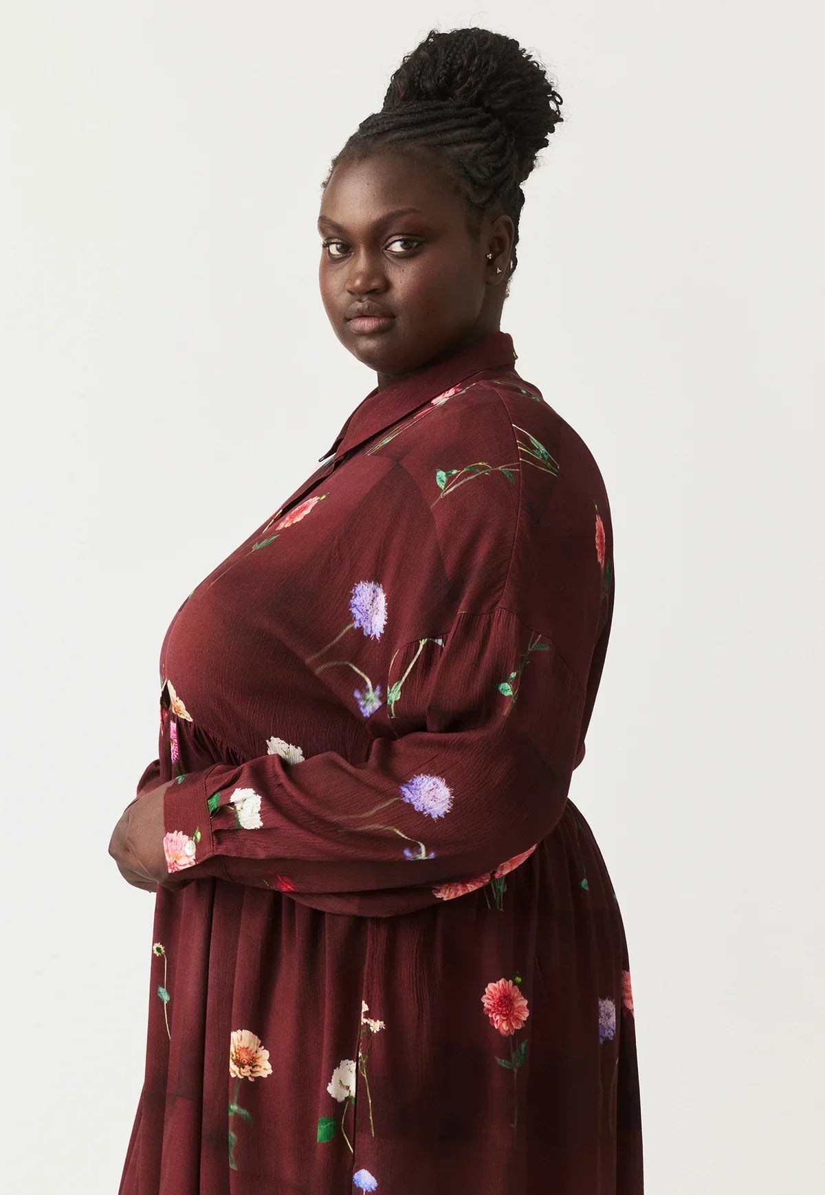 Plus size woman in burgundy floral print dress with long sleeves and collar