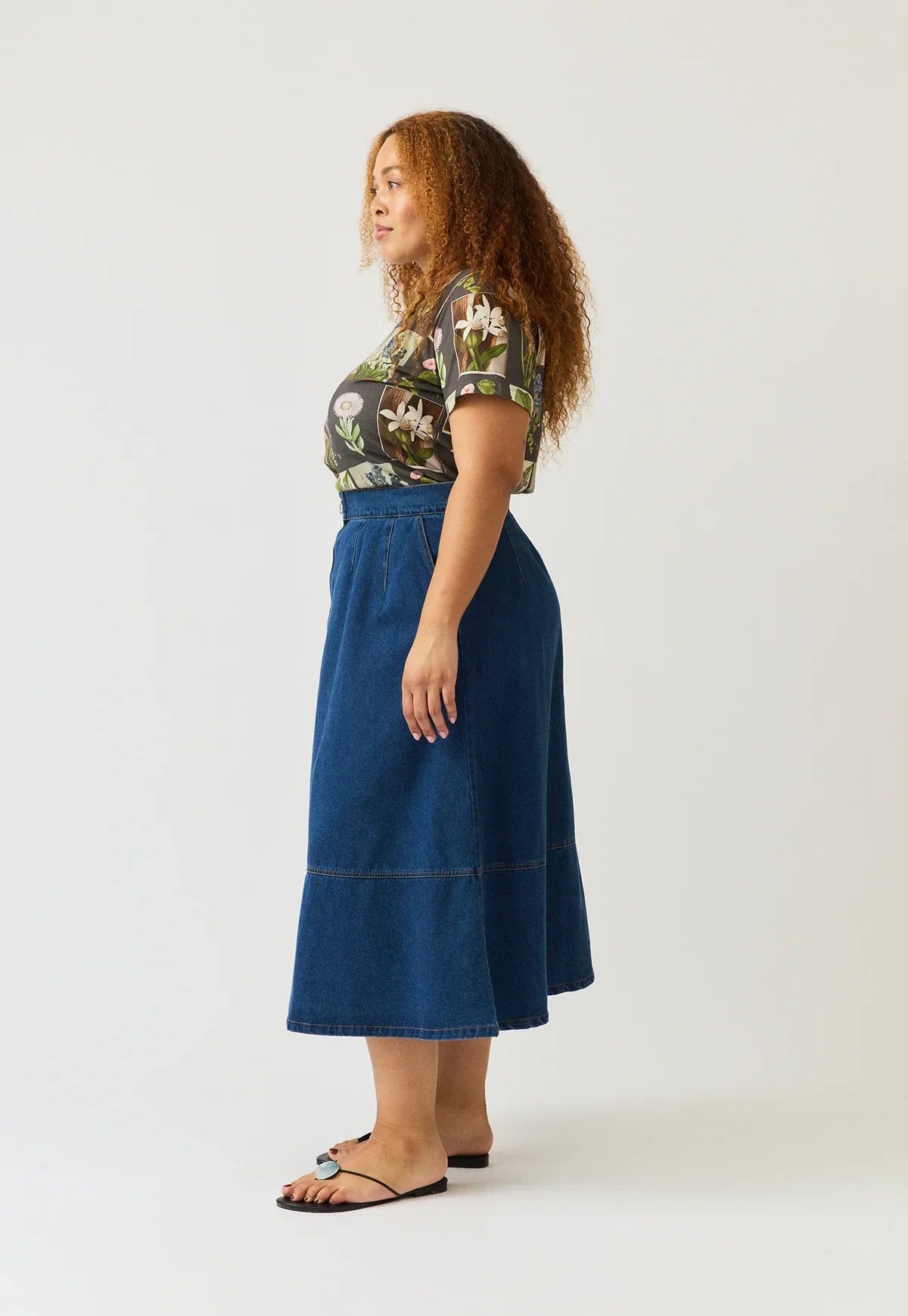 Woman wearing NANCYBIRD Aries Denim Skirt in dark wash and a floral t-shirt