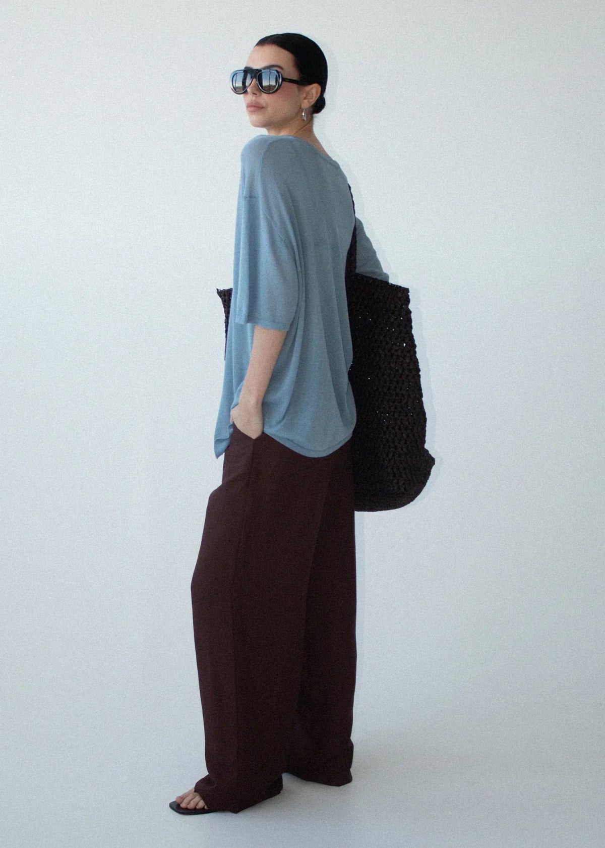 Woman wearing STAPLE THE LABEL Orla Oversized Knit Tee in Dusty Blue and brown trousers.