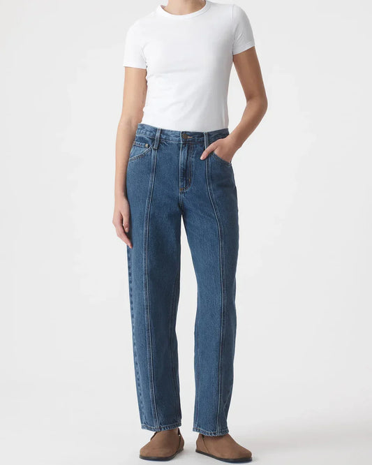 Woman wearing high-waisted blue jeans with white tee and brown flats, casual women's fashion