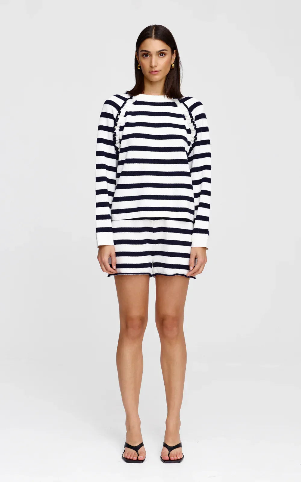 Navy and white striped long-sleeve knit dress with ruched shoulders, paired with black sandals